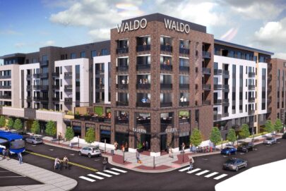 A modern multi-story apartment complex labeled Waldo features ground-floor retail, large windows, balconies, pedestrians, cyclists, and a city bus at an intersection on a sunny day.