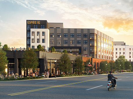 Modern multi-story apartment building labeled “RAMBLER” with large windows, greenery, and people on patios; a person on a scooter rides along the street in front under a partly cloudy sky at sunset.